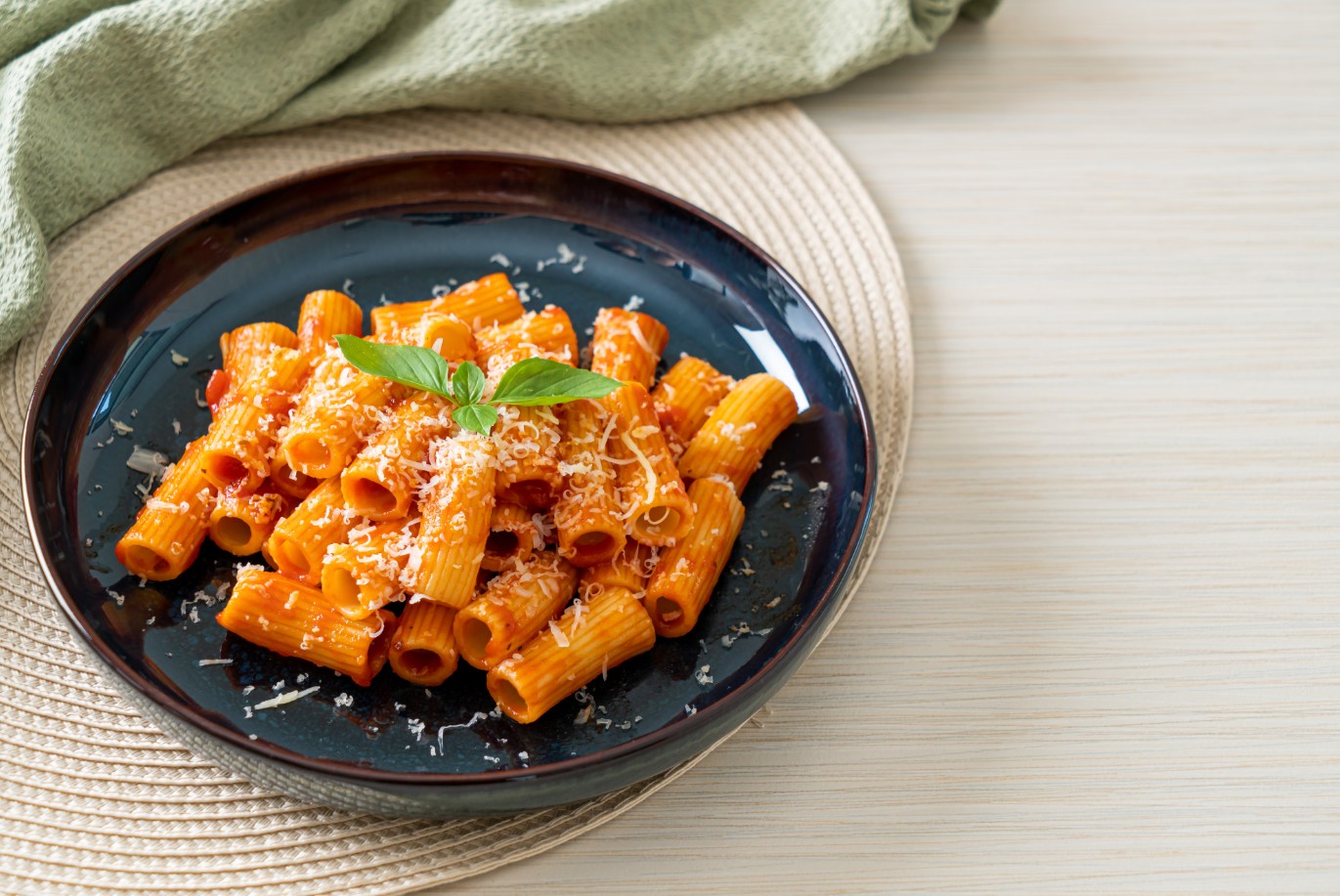 פסטה פנה בקערת הגשה, עם גבינת פרמזן מעל.