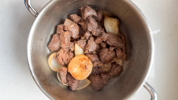 מחממים בסיר עמוק שמן זית עם קוביות הבשר יחד עם הבצל המקולף.