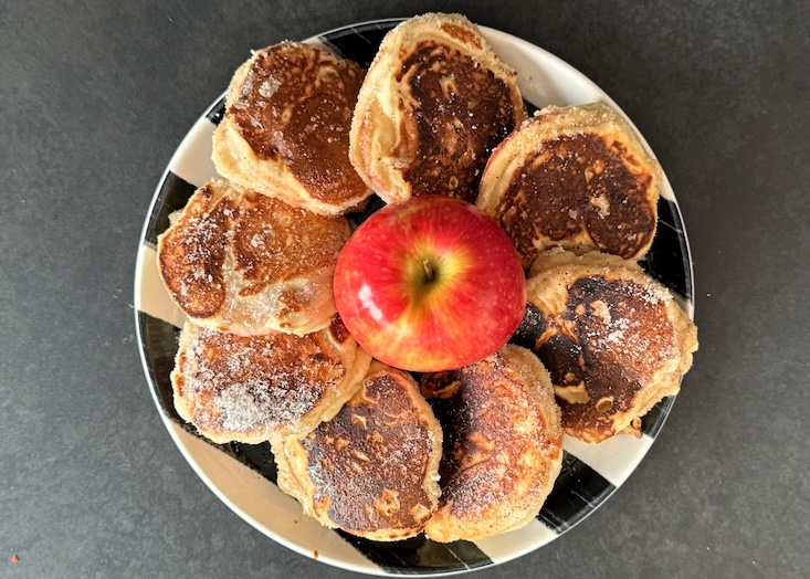 מגישים חם בצלחת, בתערובת של סוכר וקינמון, ותפוח עץ שלם בצד.