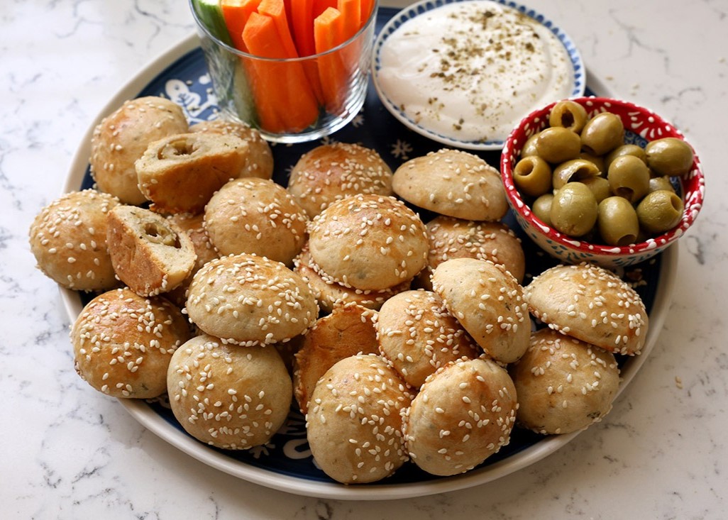 מוכן - מגישים מיני לחמניות במילוי זיתים, לצד זיתים, ירקות ושמנת חמוצה.