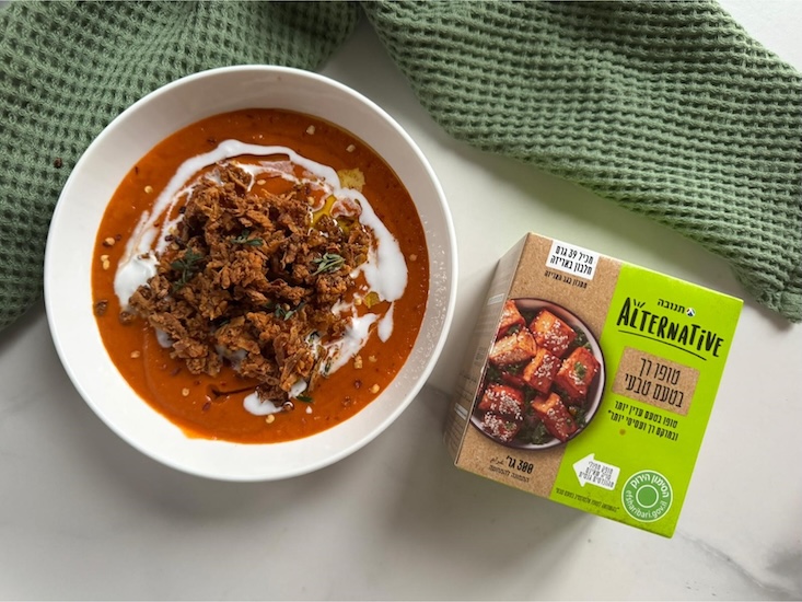 מרק עגבניות עם קרוטוני טופו קריספיים מעל, זילוף של קרם קוקוס, מעט צ’ילי גרוס ועלי טימין.