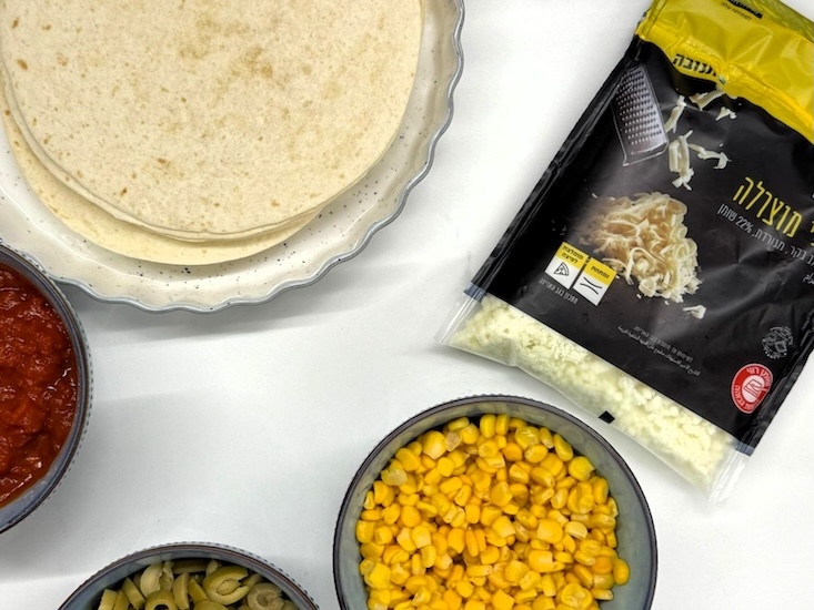 שלב 1 מצרכים: פתיתי מוצרלה, טורטיות, רוטב עגבניות, תירס וזיתים.