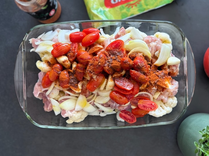 מוסיפים לתבנית את הפרגיות החתוכות, הבצל, עגבניות השרי החצויות ושיני השום השלמות.