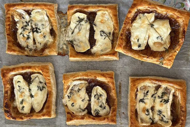 קוביות בצק עלים עם ריבת בצל, קממבר וטימין אפויות על מגש אפייה.