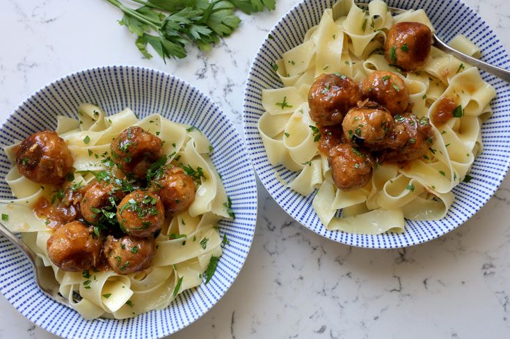 קציצות טופו עם בצל מקורמל מוגשות על פסטה.