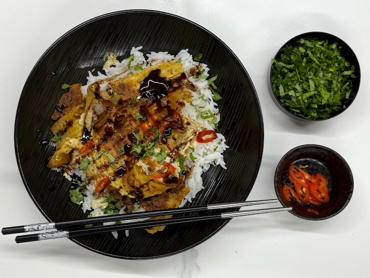 שווארמה דונר טופו עם אורז לבן, בקישוט כוסברה טרייה ופרוסות צ'ילי אדום חריף.