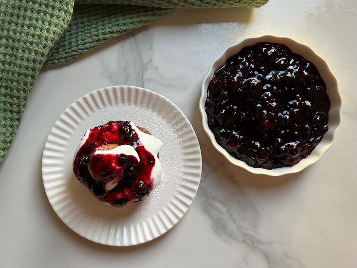 מניחים טבעת על צלחת, מעליה שמנת חמוצה ומעליה רוטב פירות יער, במרכז מניחים כדור קטן, שוב שמנת חמוצה ומעל פירות יער, בוזקים מעל אבקת סוכר ומגישים.