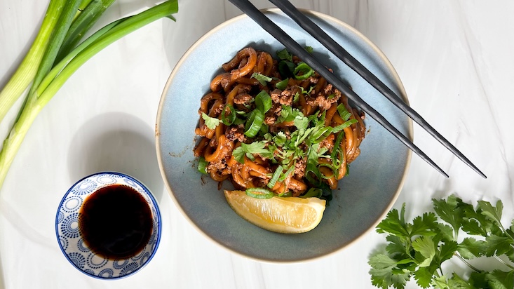 מגישים את הנודלס עם בצל ירוק טרי, כוסברה, פרוסת ליים (או לימון)