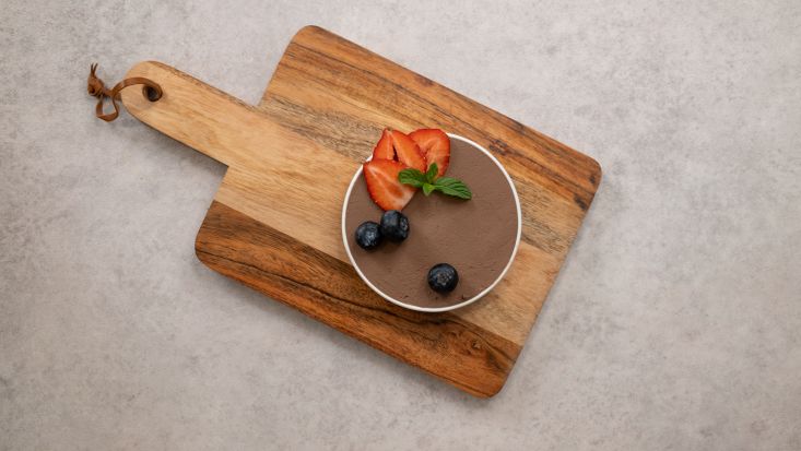 מקשטים את מוס השוקולד הטבעוני עם תותים ואוכמניות.