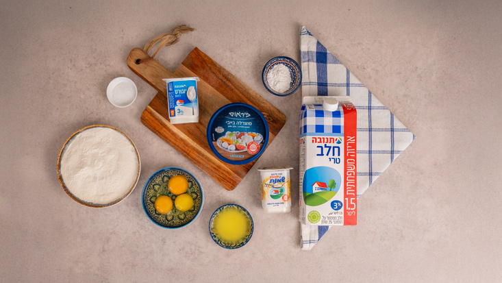 מצרכים 3 ביצים 2 כפות סוכר חום 150 מ״ל יוגורט תנובה 3% 200 מ״ל שמנת חמוצה של תנובה ⅓ כוס חלב תנובה 50 גרם חמאה מומסת כוס ורבע קמח שקית אבקת אפייה ½ כפית מלח בייבי מוצרלה של פיראוס
