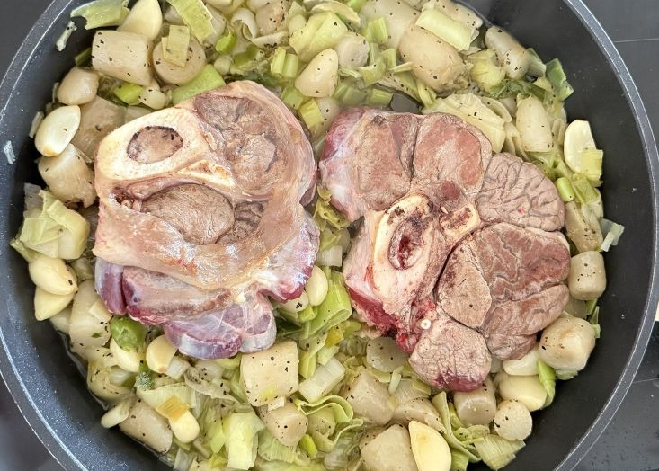 מניחים את הבשר על הארטישוק, הכרישה והשום בסיר.