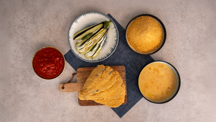 טובלים כל חציל בביצה ואז מצפים בפירורי לחם.