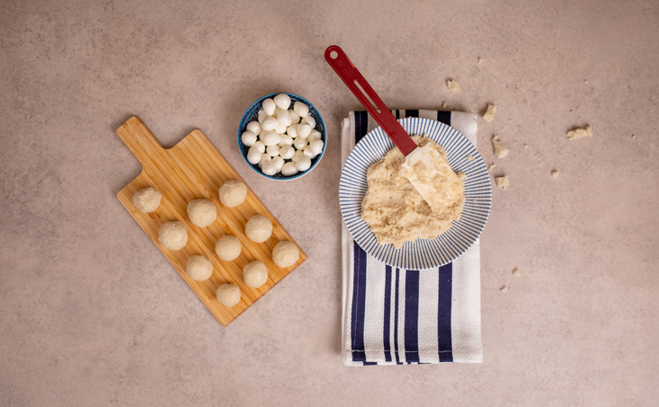 לוקחים מעט מהתערובת, מניחים במרכז בייבי מוצרלה של פיראוס וסוגרים סביב הגבינה ליצירת כדור