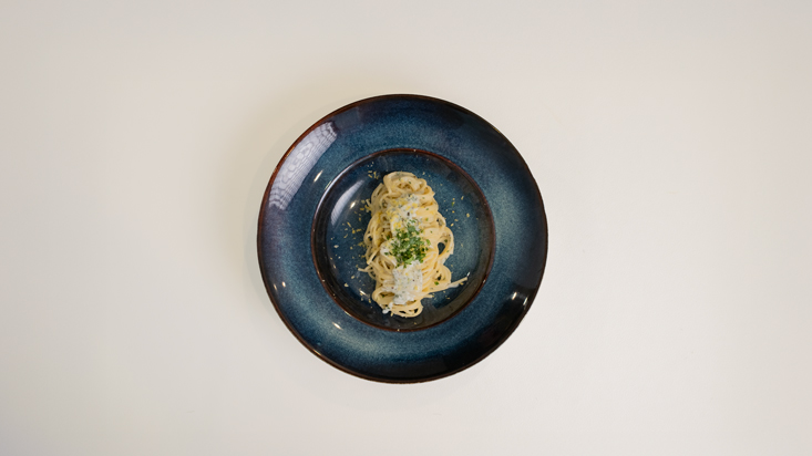 פסטה ברוטב יוגורט מוגשת עם פטרוזיליה קצוצה ופרמזן מלמעלה.