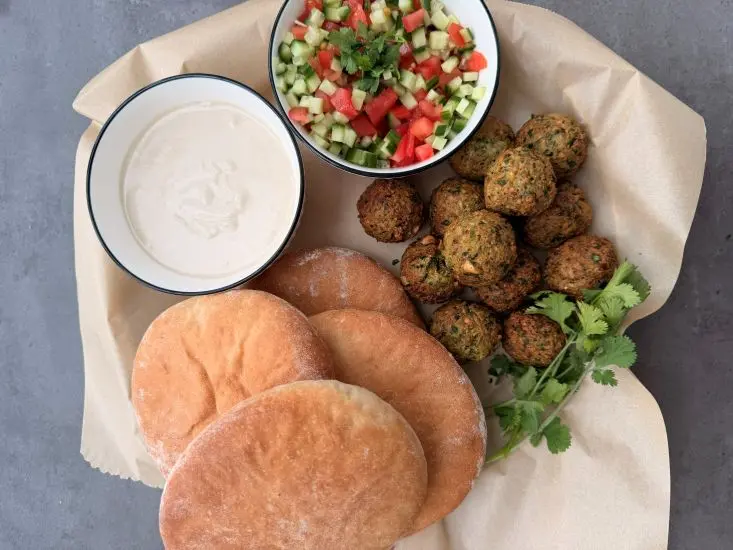 פלאפל מאדממה עם פיתה, סלט ירקות, חצילים קלויים טחינה וחריף.