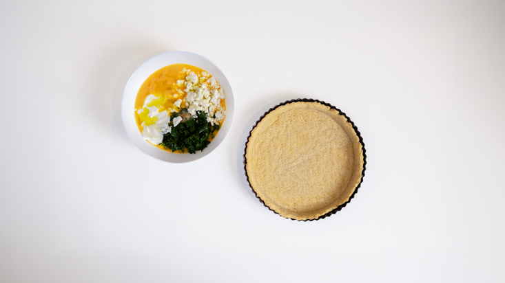 תבנית מרופדת בבצק, לצד תערובת המצרכים לקיש.